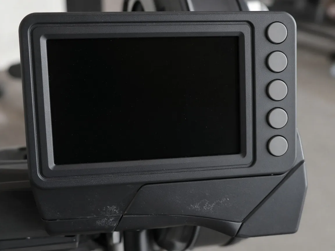 A dark monitor with a blank screen and four round buttons on the right